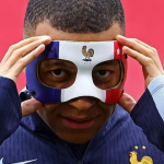 Photo of Mbappe's mask adjustment.