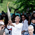 Photo of Snoop Dogg carrying the Paris 2024 Olympics flame.