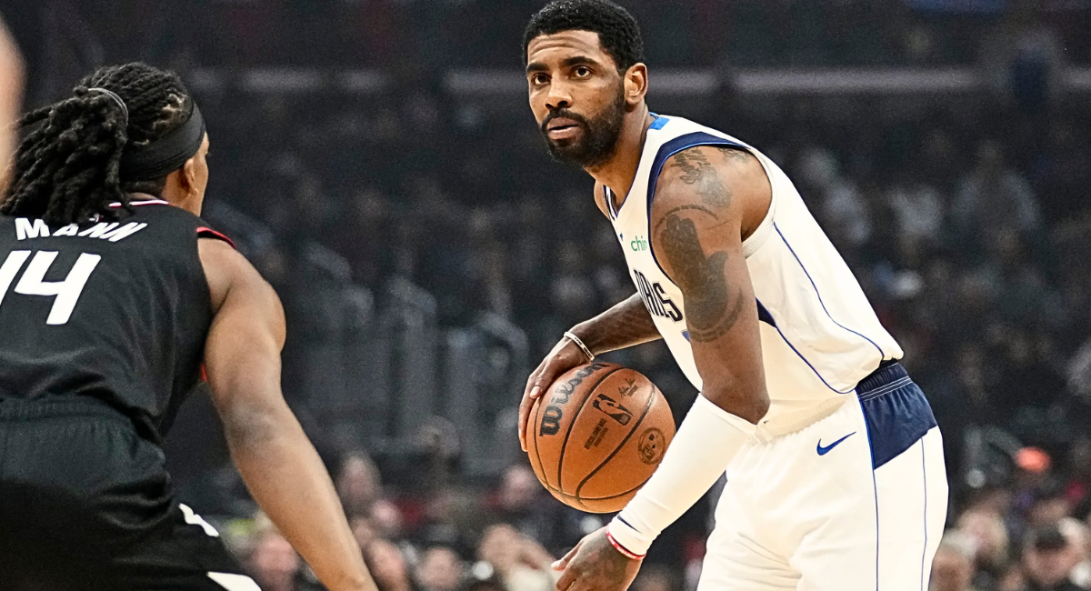 Kyrie Irving, wearing a Dallas Mavericks jersey, celebrates on the court with intensity after a dominant performance, emphasizing the importance of defending their home arena.