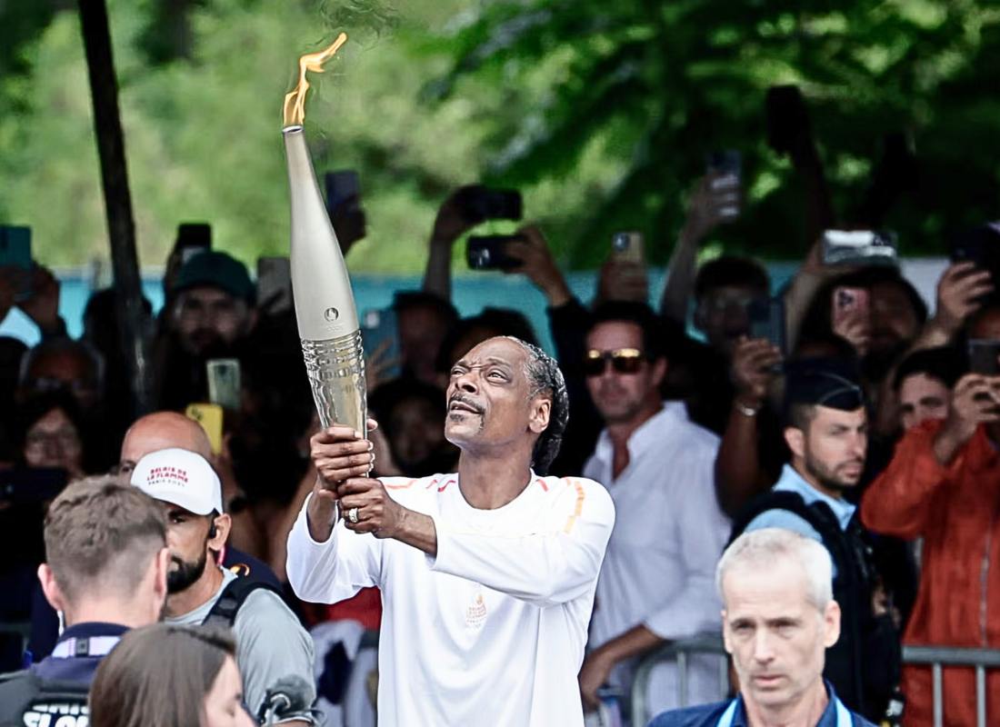 Photo of Snoop Dogg carrying the Paris 2024 Olympics flame.