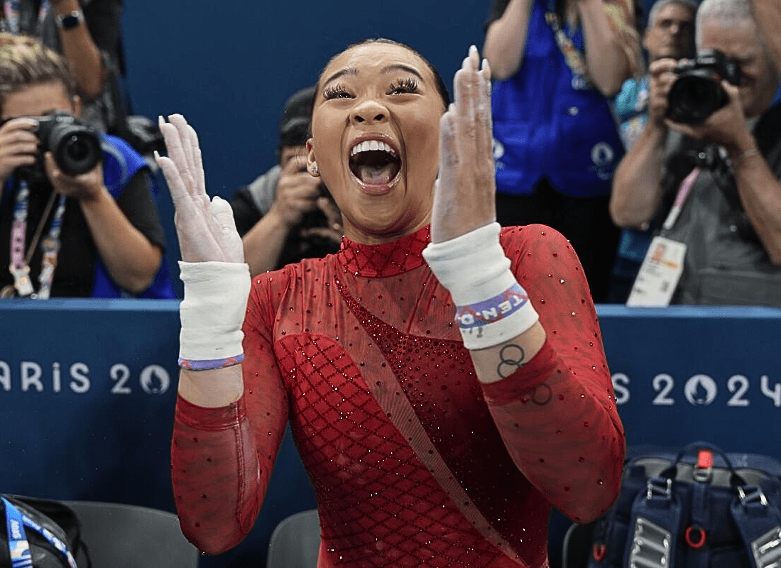 Suni Lee performing on the uneven bars during the 2024 Paris Olympics, showcasing her skill and earning a bronze medal.